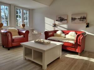 拉特考Landhotel garni zur Linde的客厅配有2把红色椅子和咖啡桌