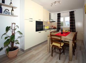 西利皮Apartment Milenka的一间带木桌的厨房和一间餐厅
