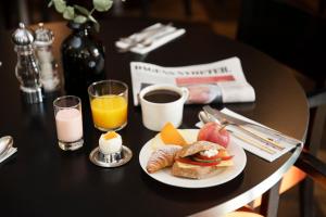 斯德哥尔摩ProfilHotels Nacka的一张桌子,上面放着一盘早餐食品和报纸