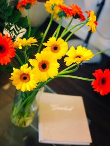 苏黎世诺伊菲尔德酒店的花瓶,花瓶上满是黄红花,花瓶旁边放着一张卡片