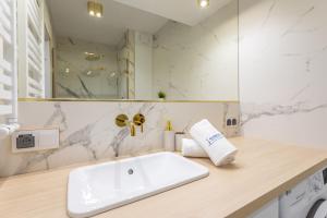 斯维诺乌伊希切Ambria Apartments Dębina的浴室配有白色水槽和淋浴。