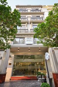 胡志明市Nikko Hotel - The Classy Life的前面有树木的建筑前的商店