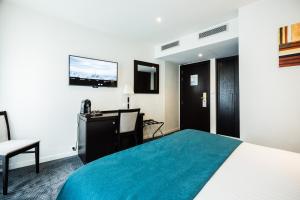 巴黎拉内公园酒店的酒店客房配有一张床、一张书桌和一台电视。