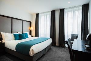 巴黎拉内公园酒店的酒店客房设有一张床、一张书桌和窗户。
