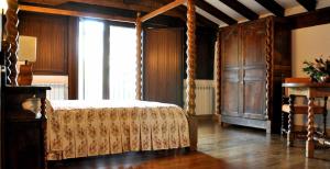 Oronoz-MugaireCasa rural Barbenea的一间卧室设有一张天蓬床和大窗户