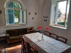 因佩里亚Casa Gazzano的客厅里设有一张带红色鲜花的桌子