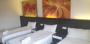 希灵登希思罗酒店的一间设有两张床的客房,墙上挂着一幅画