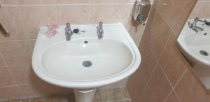 希灵登希思罗酒店的浴室配有白色水槽和卫生间。