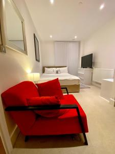 伦敦PrimeLodge Excel的客厅配有红色的沙发和床。