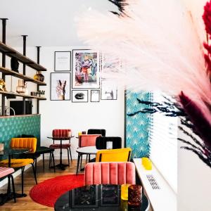 赞德沃特Boutique Lodge Zandvoort的一间餐厅,房间内设有五颜六色的椅子和桌子