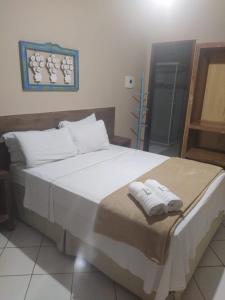 佩尼多Pousada Casa do Bosque的一间卧室配有一张大床和毛巾