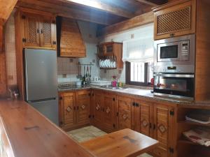 隆达El Nogal的厨房配有木制橱柜和不锈钢用具