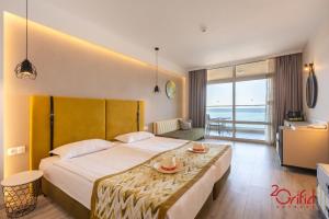 金沙GRIFID Encanto Beach Hotel - MediSPA, Ultra All Inclusive & Private Beach的酒店客房设有一张大床和一张桌子