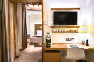巴黎精选酒店的酒店客房配有书桌和电视。