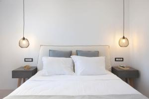 安迪帕罗斯岛克洛斯村旅馆的一间卧室配有白色床和2个床头柜