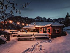 吉梅尔瓦尔德格美湾德山地旅馆的雪覆盖的建筑,雪地里长着长椅