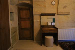 格雷梅DIADEM CAPPADOCIA GUEST HOUSE & HOSTEL的客房设有木桌和木门。