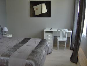 罗卡马杜尔Chambres d'hôtes Les Lavandes Rocamadour的一间卧室配有一张床和一张桌子及椅子