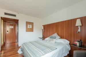 潘普洛纳Micampus Pamplona的一间卧室配有一张大床和木制床头板
