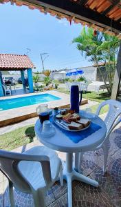 伊泰普阿苏Pousada da Praia的一张桌子,上面有盘子的食物,放在游泳池边