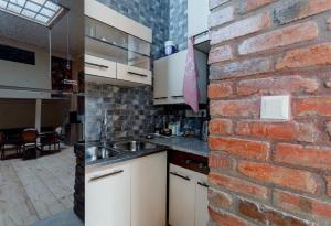 第比利斯lovely Dulcet Loft In Center Of Rustaveli的厨房设有砖墙和水槽