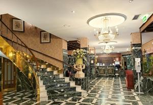 巴利亚多利德Hotel Imperial的酒店大堂设有楼梯和吊灯