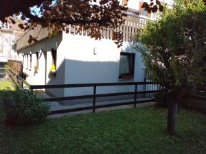 博尔扎诺Peters Guest House的一座白色的建筑,在院子旁边设有黑色的围栏