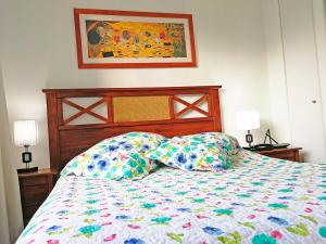 圣地亚哥Santiago Center Apart的一张带五颜六色的被子和两个枕头的床