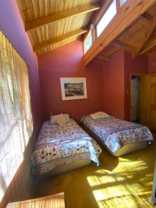 皮斯科艾齐Pisco Elqui HolidayHome的紫色墙壁客房的两张床