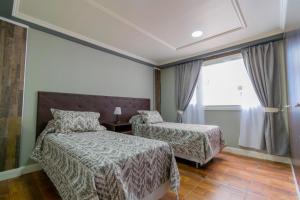 乌斯怀亚ABC DEPARTAMENTOS的酒店客房设有两张床和窗户。