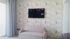 希法Studio Jebel Sifah Resort Golf Lake G 14 - 201的客厅配有椅子和墙上的电视