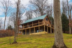 South BloomingvillePine Creek HC Hocking Hills Cabins的一座带绿色屋顶的大型木制房屋