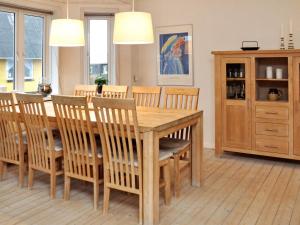 曲博伦Holiday home Thyborøn IV的一间带木桌和椅子的用餐室