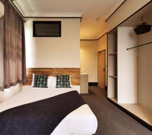 悉尼悉尼克雷西酒店的一间卧室设有一张床和一个大窗户