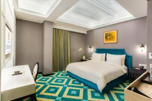 雅加达Hotel Des Indes Menteng的配有一张床和一张书桌的酒店客房