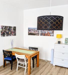 莱比锡City Apartment Leipzig的一间带木桌和椅子的用餐室