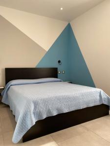 坎诺比奥Azalea Appartamenti的一间卧室配有一张蓝色墙床