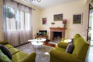 丰沙尔Villa Cosy Nook的客厅设有绿色椅子和壁炉