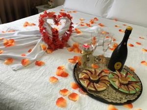 都拉斯娜伊丝酒店的床上有一瓶葡萄酒和鲜花