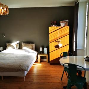 HiersacLe Bonheur- Suite Cognac的一间卧室配有一张床、一张桌子和一个梳妆台