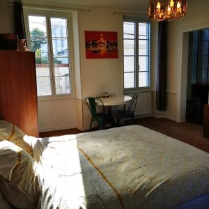 HiersacLe Bonheur- Suite Cognac的卧室配有床、桌子和窗户。