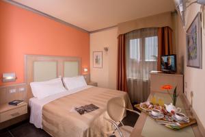 利沃诺地中海酒店的酒店客房,配有一张床和一张桌子,上面有盘子的食物