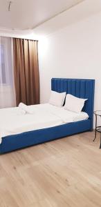 科克舍套Аблайхана 1/3的蓝色床头板的客房内的两张床