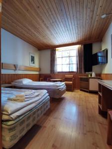 萨利色尔卡萨利色尔卡啤酒旅馆的配有木天花板的客房内的两张床