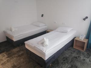 戈乌达普Pokoje Hotelowe LUPUS的配有白色床单的客房内的两张床