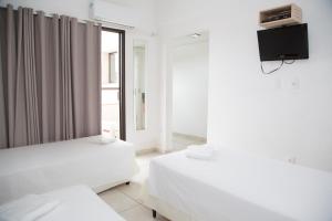 索罗卡巴索罗卡巴特雷沃广场酒店的配有两张床铺的客房,墙上配有电视