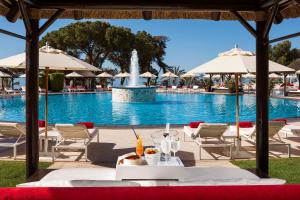 马贝拉Hotel Don Pepe Gran Meliá的一个带桌椅的游泳池和一个喷泉