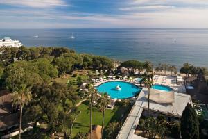 马贝拉Hotel Don Pepe Gran Meliá的享有带游泳池和海洋的度假村的空中景致