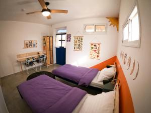 OdemOdem Guest House的紫色床单的客房内的两张床