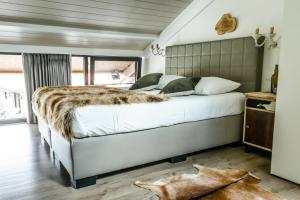 布鲁日Hoeve Chartreuse的一间卧室配有一张大床和一张仿毛皮毯子